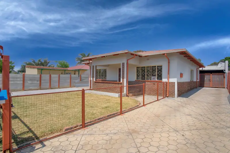 Suburban house with a fenced yard and paved driveway